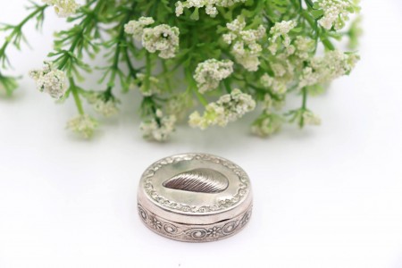 Caixa de comprimidos em prata com relevos e mexilhão em vulto perfeito na tampa